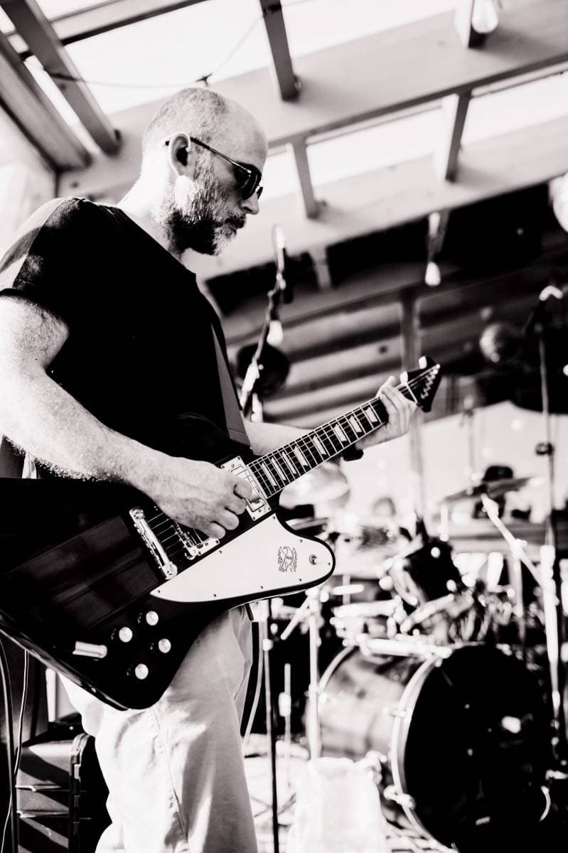 Guitarrista dos The Vibrators Band durante uma atuação, com o baterista em segundo plano